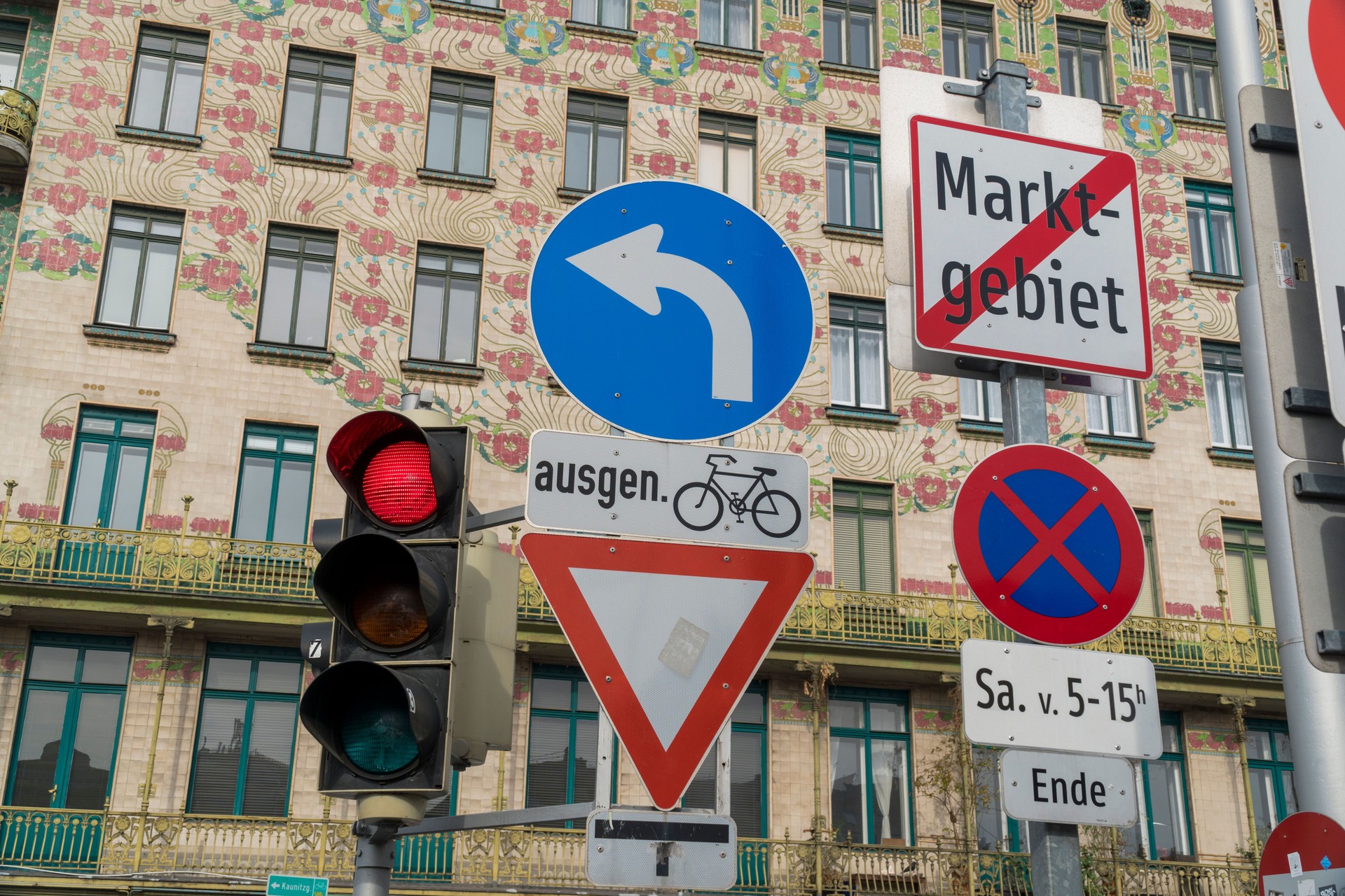 Blumenbemaltes Gebäude mit Verkehrszeichen im Wiener Naschmarkt.